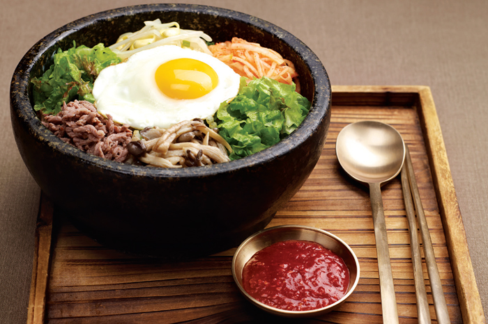 Bibimbap: Cooked rice served with fresh and seasoned vegetables, minced beef, and chili paste